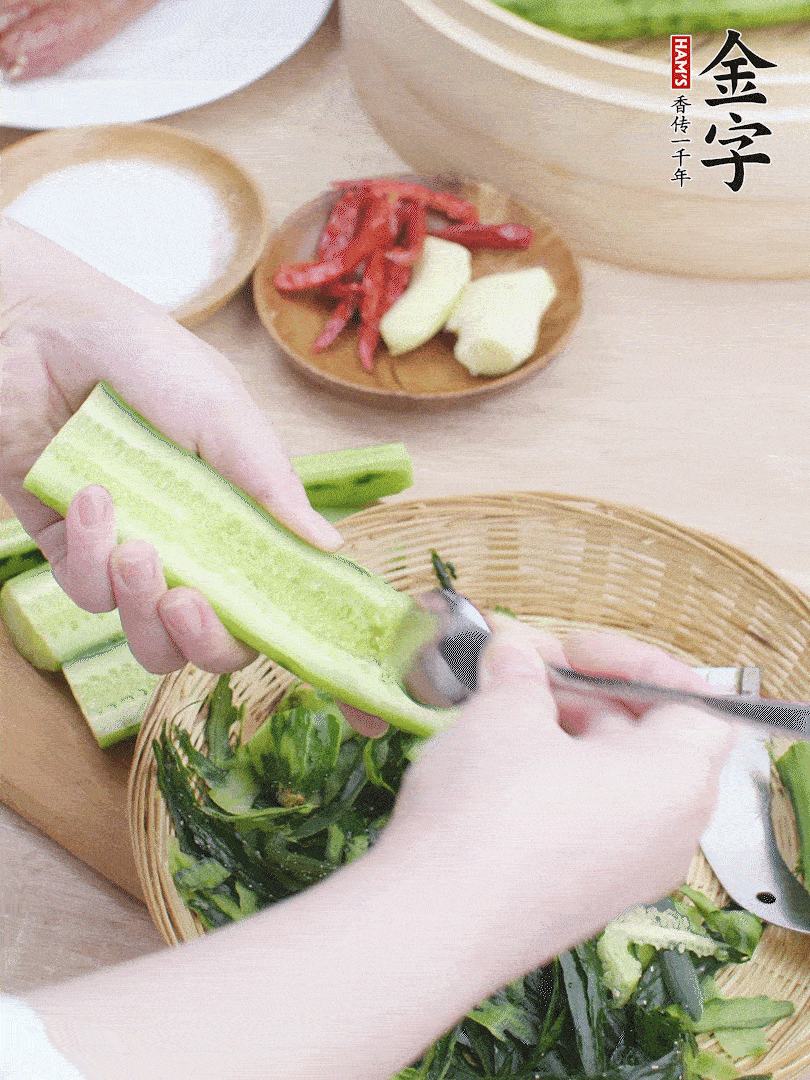 黃瓜削皮，對半切開，勺子挖去內瓤，斜刀切片。青蒜斜刀切段。